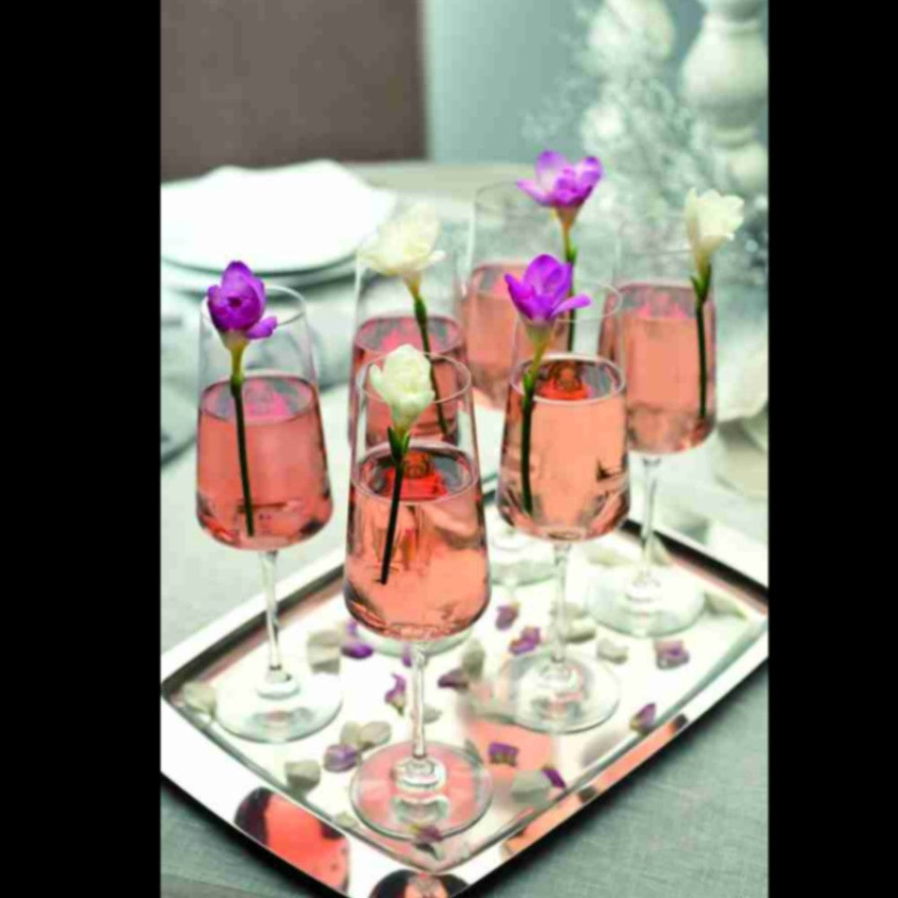 Кристални чаши ARIA RCR Italy сервирани със шампанско розе и декорация свежо цвете върху елегантен поднос върху маса за кетъринг.