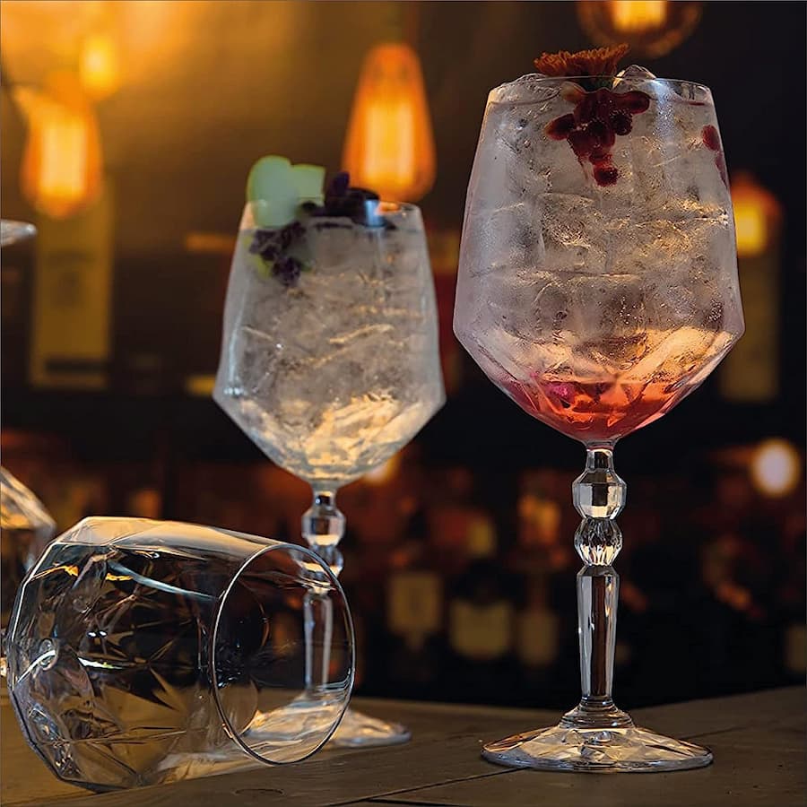 Чаши ALKEMIST RCR кристал LUXION 670 мл съдържащи коктейли в бар обстановка.